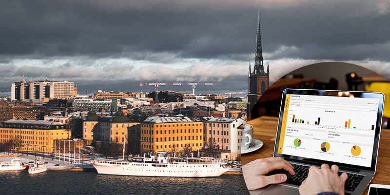 Vy över Stockholm med underhållsplan i Planima på laptop bredvid